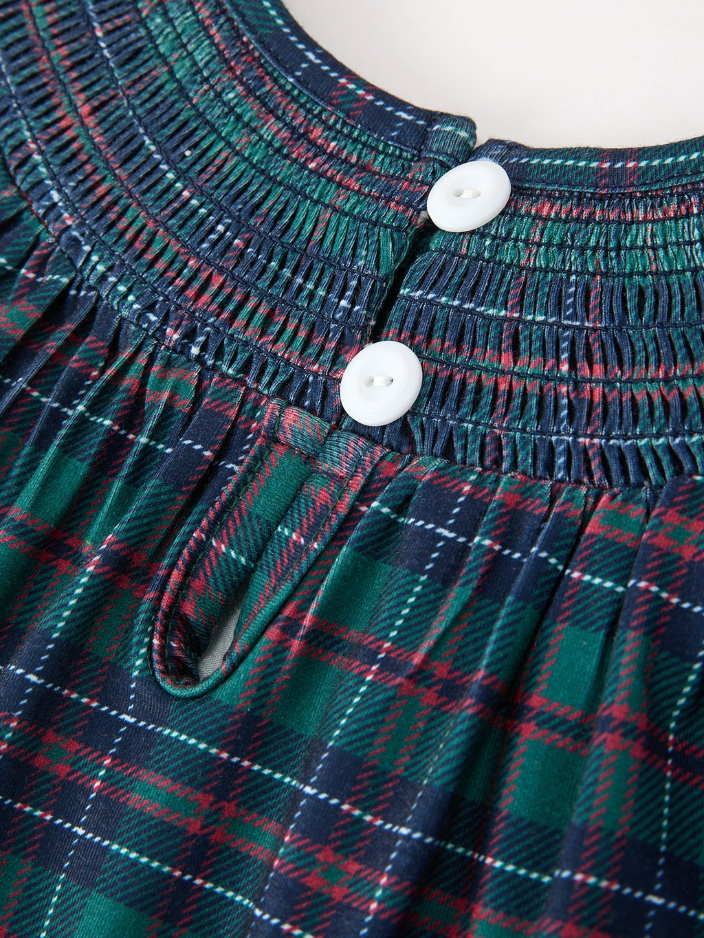 Teal and red plaid bodice with smocking and two white buttons
