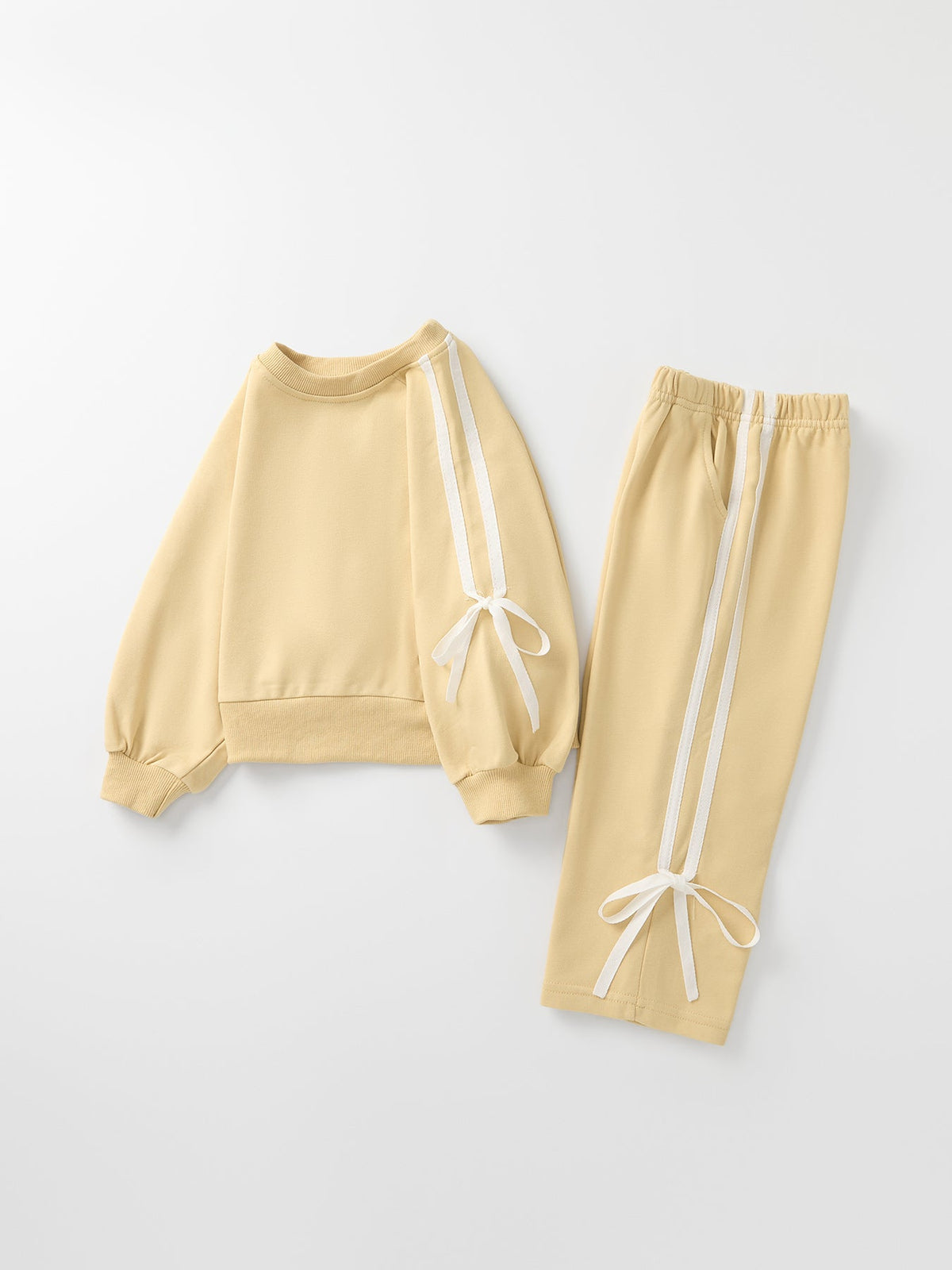 Girls cream sweatshirt and pants set with bow-tie ribbon trim and side stripe detailing