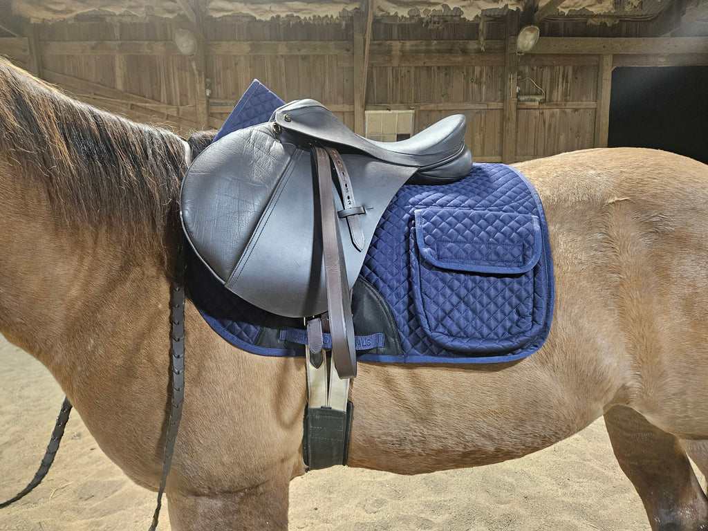 Blue quilted English saddle pad with half fleece lining and side pocket on a standing horse