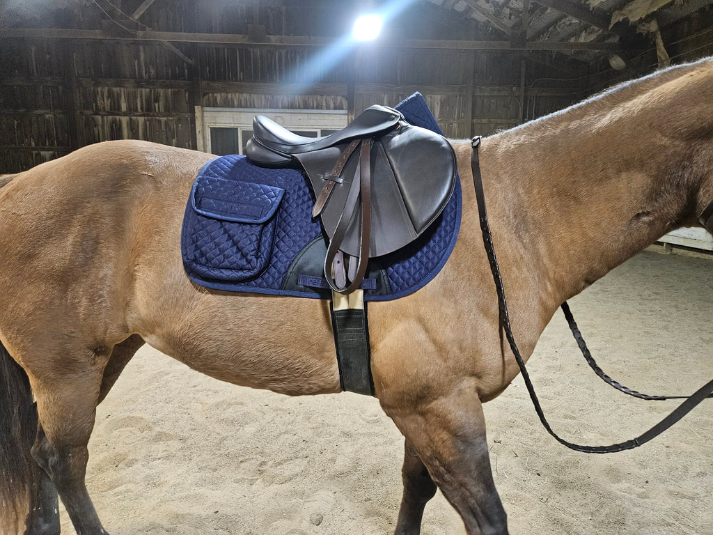 Blue quilted English saddle pad on a horse with half fleece lining and side pocket