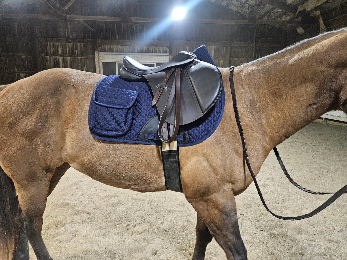 Blue quilted English saddle pad on a horse with half fleece lining and side pocket