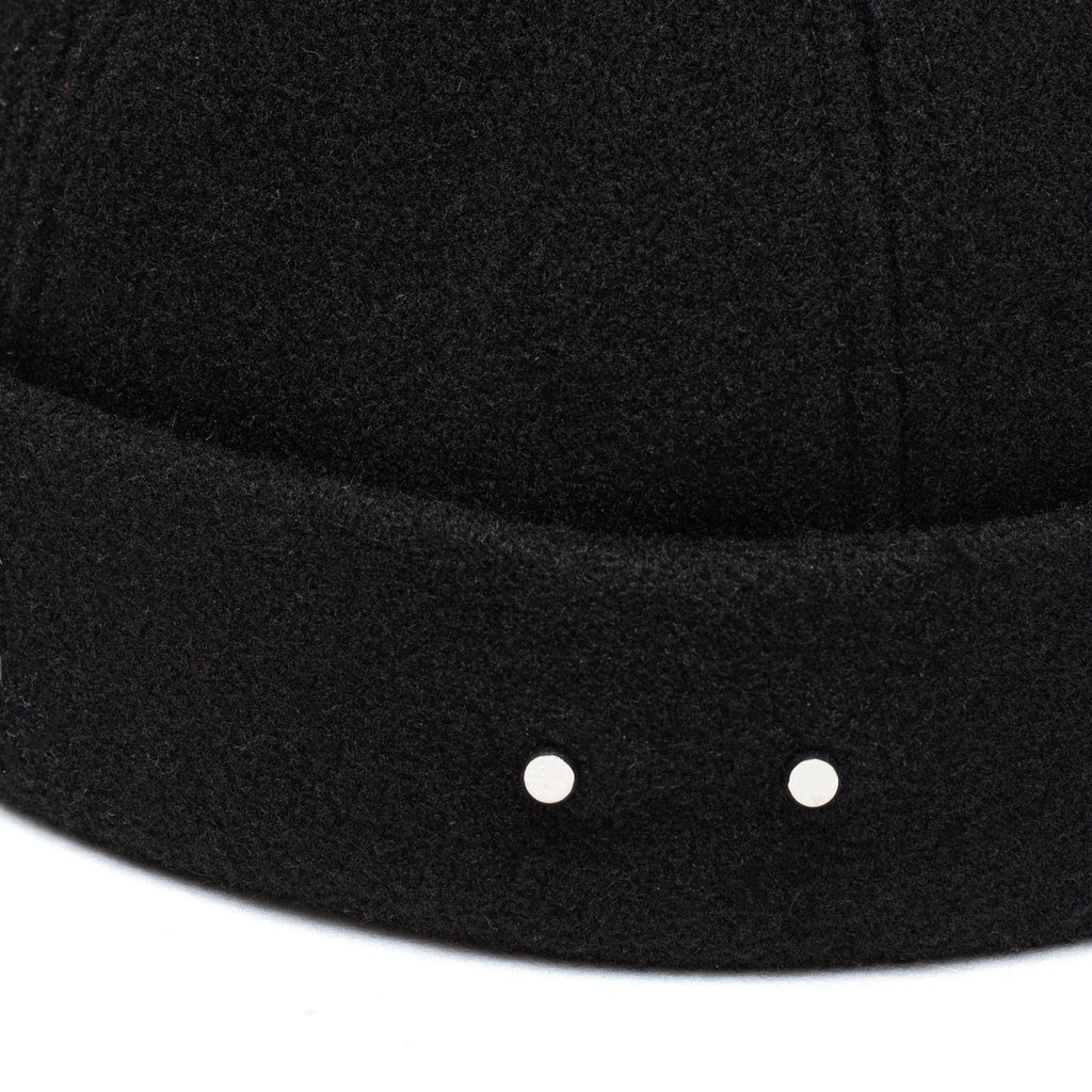 Black docker cap brim with two metal stud details