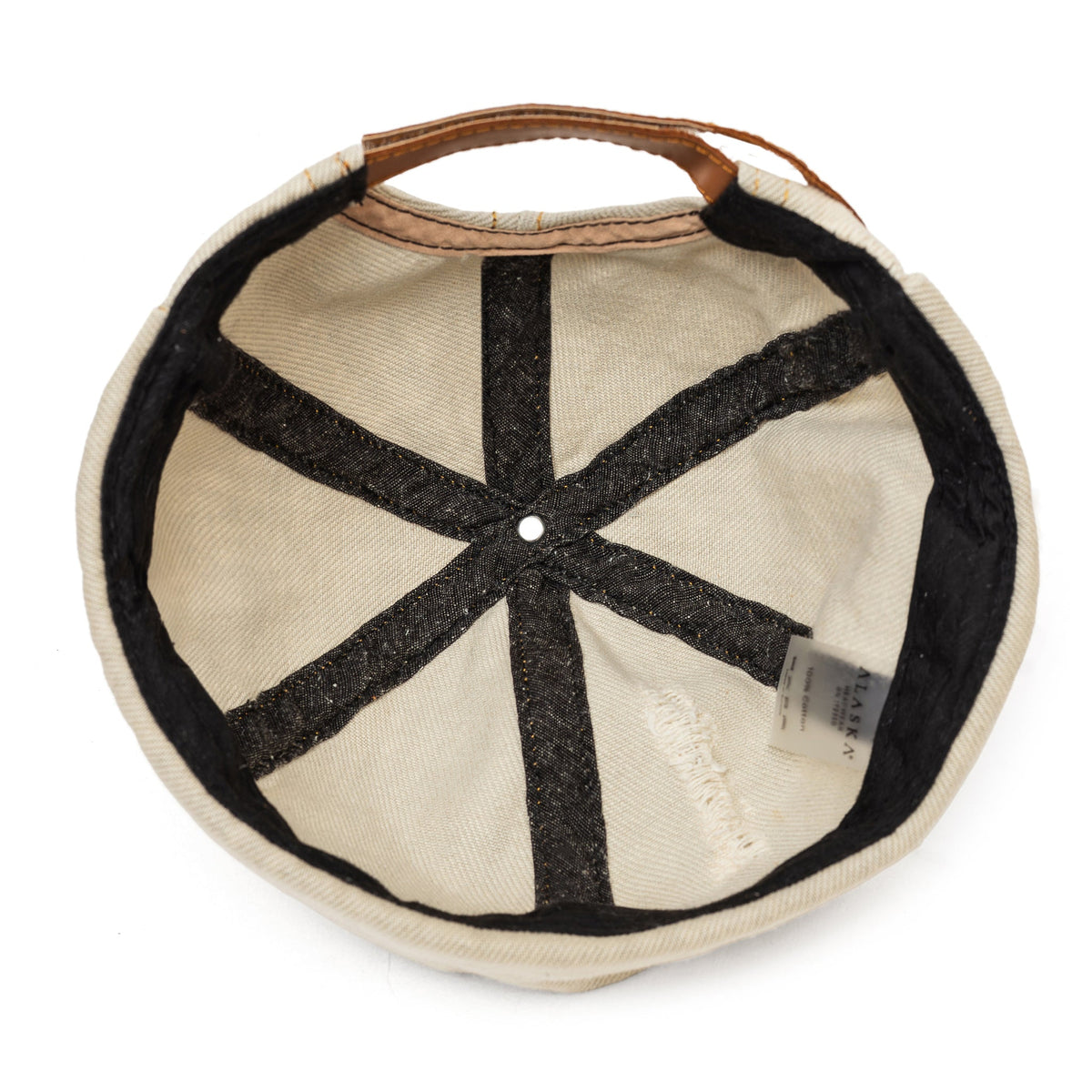 Beige canvas Docker-style cap lining with black geometric panel and center button