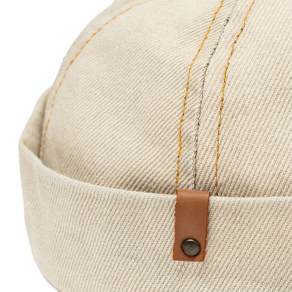 Sand denim docker cap close-up, leather adjuster with snap button
