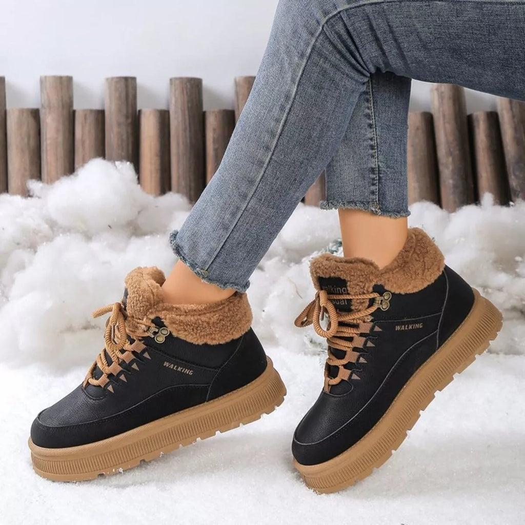 Black lace-up platform ankle boots with tan shearling trim and lace eyelets