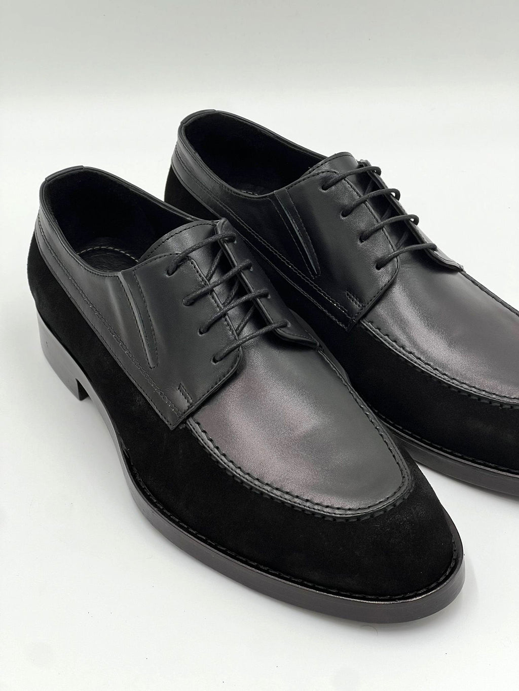 Black leather oxford lace-up shoes, side view with textured sole and stitching.