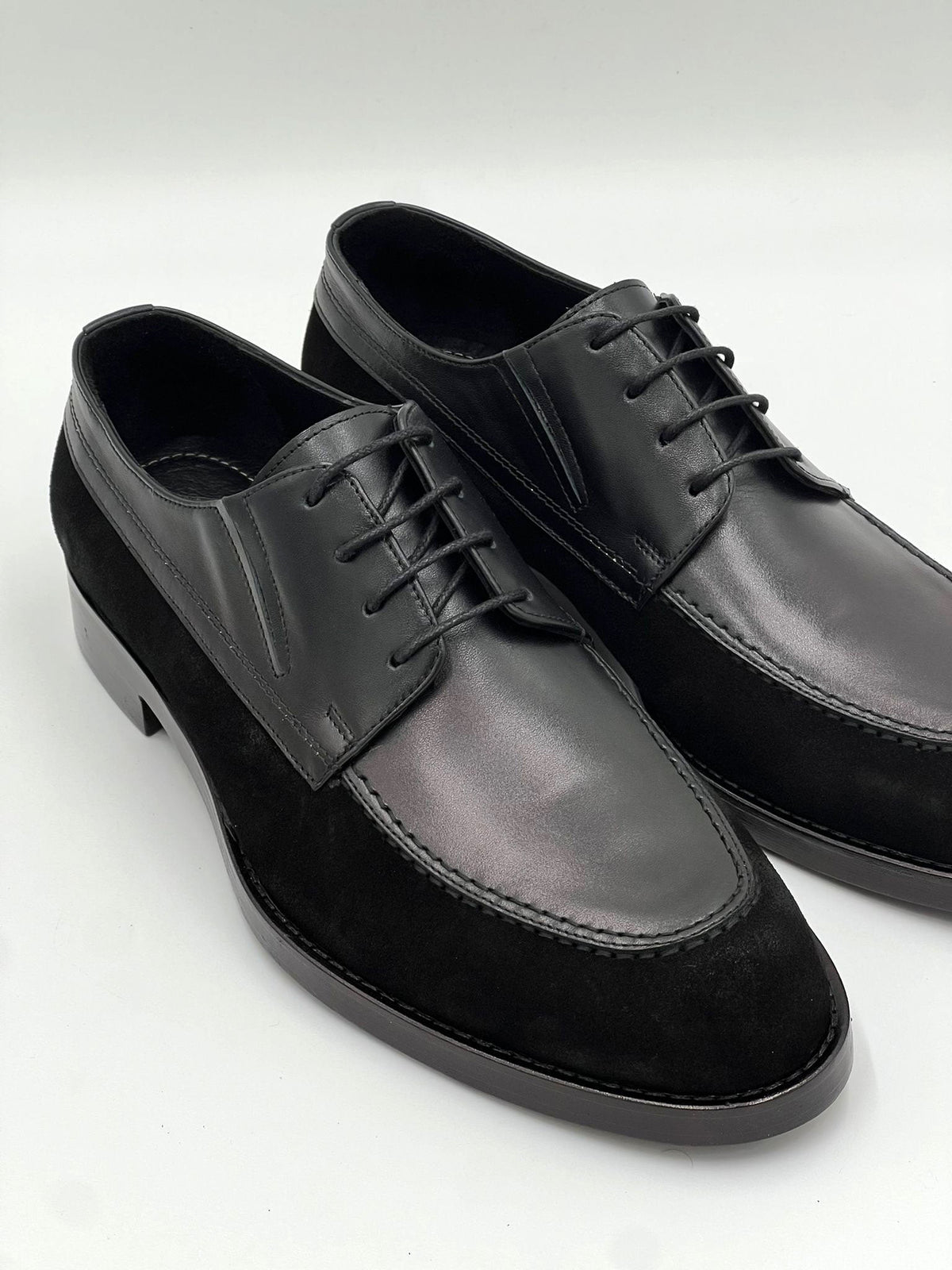 Black leather oxford lace-up shoes, side view with textured sole and stitching.