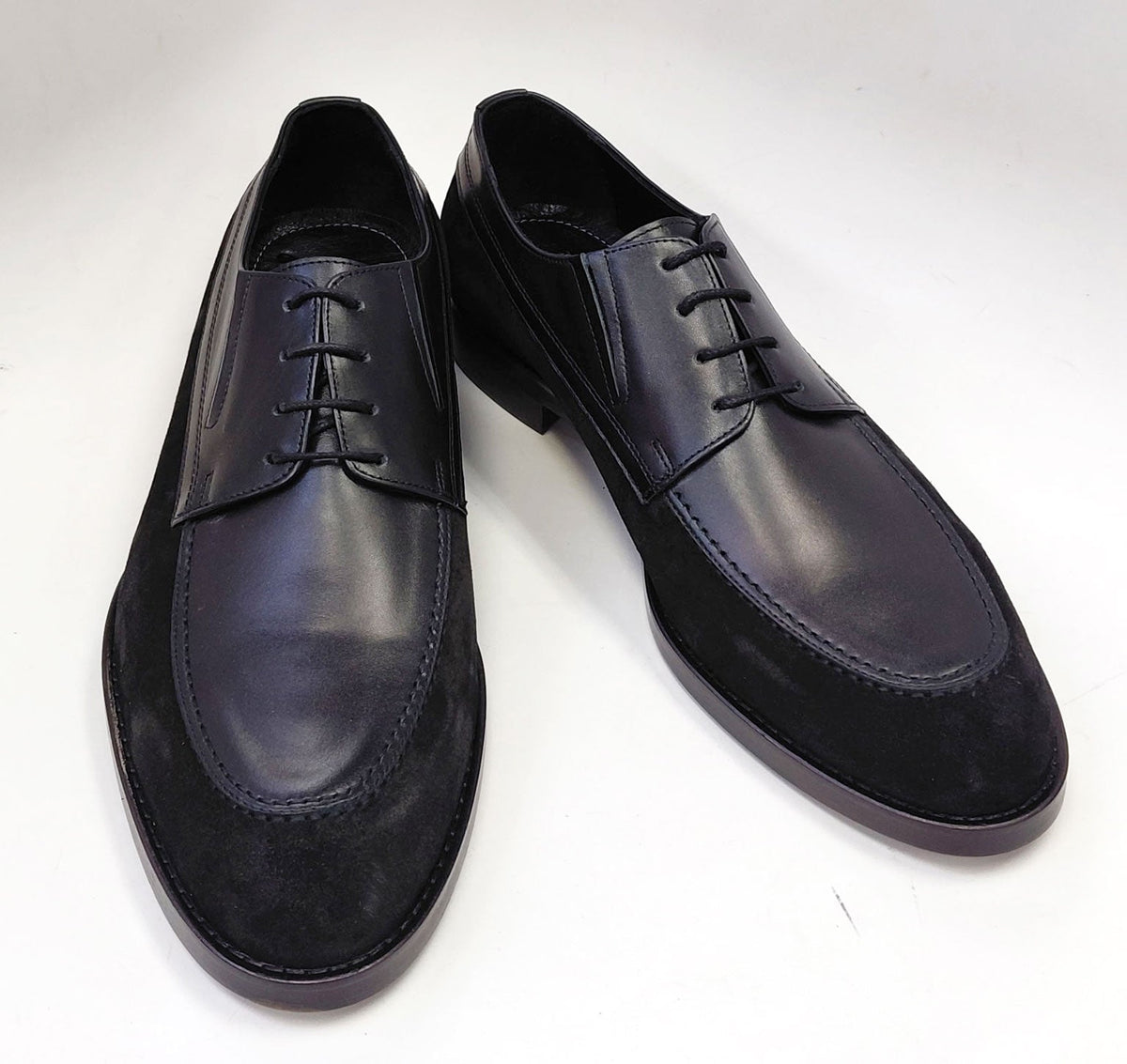 Black leather oxford shoes with lace-up front and stitched toe cap.