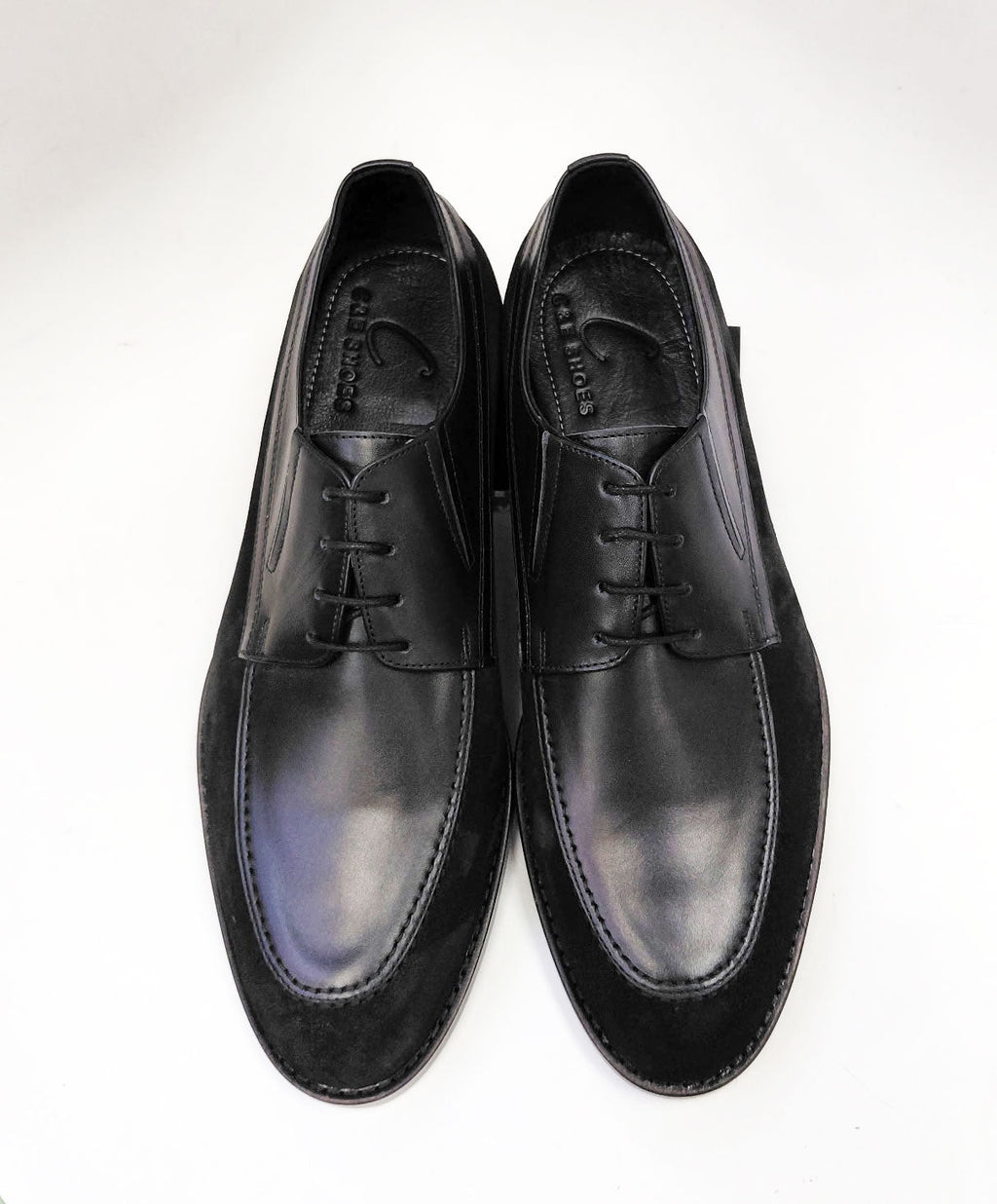 Black leather oxford shoes, lace-up front with padded tongue and stitched edge.