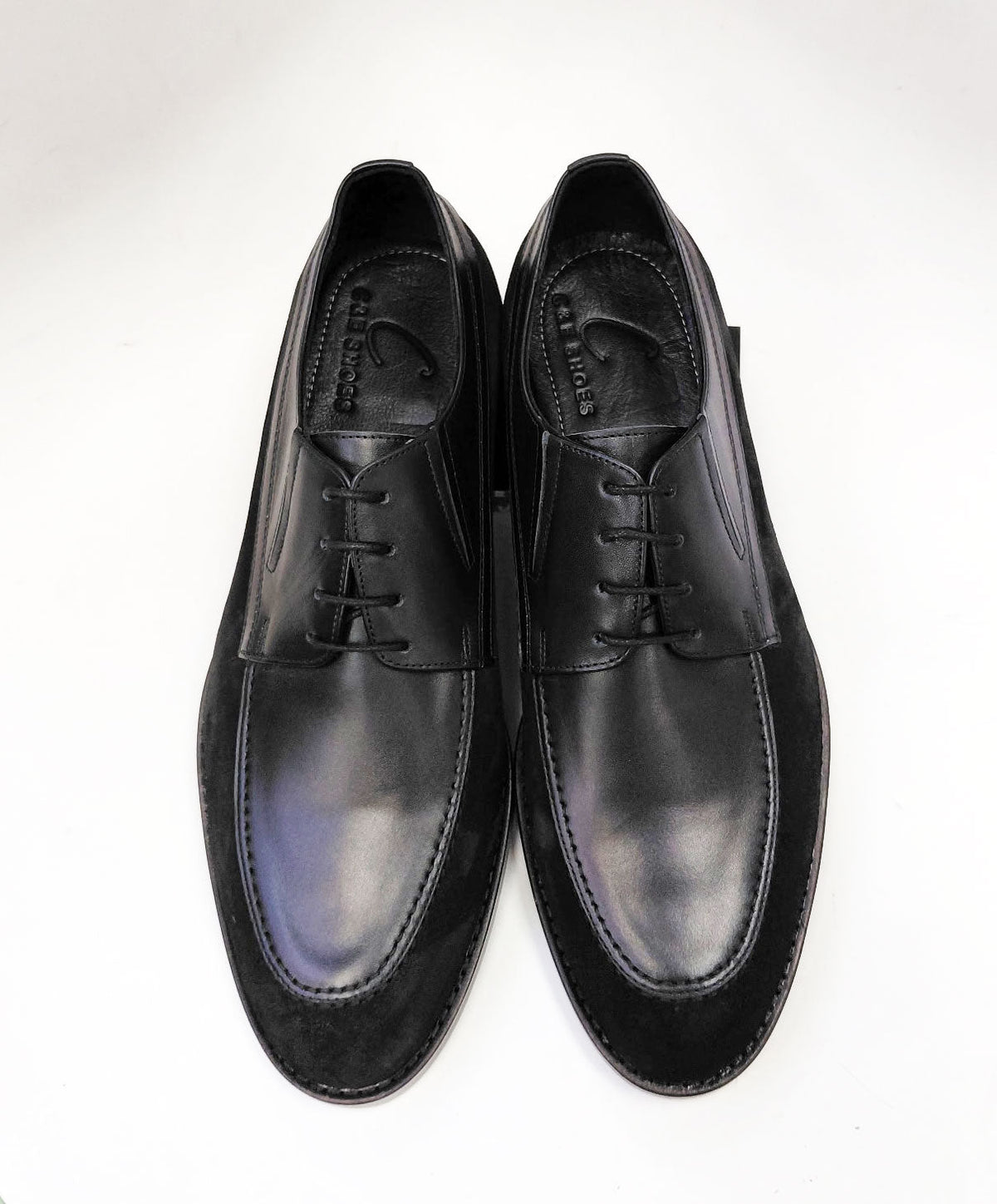 Black leather oxford shoes, lace-up front with padded tongue and stitched edge.