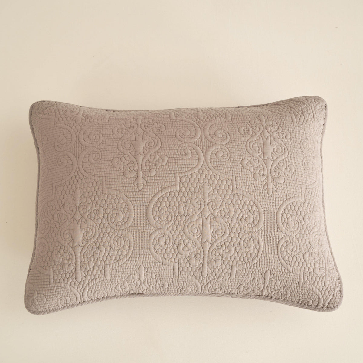 Taupe-beige decorative quilted lumbar pillow with embossed medallion motifs