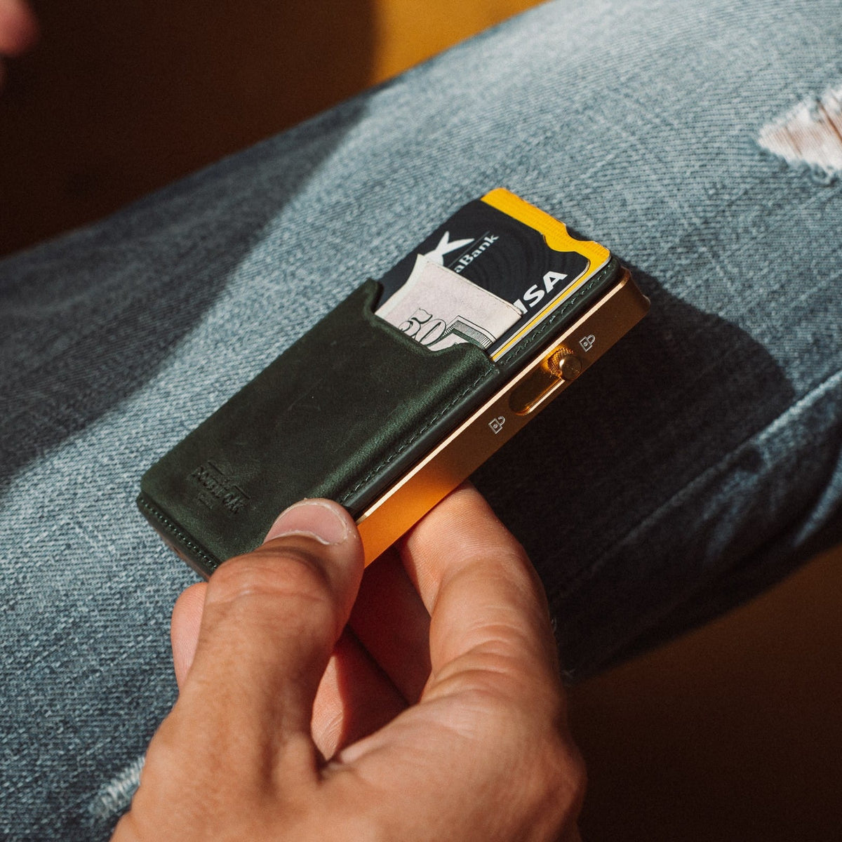Dark green leather card mod wallet with cards visible and gold-tone hardware