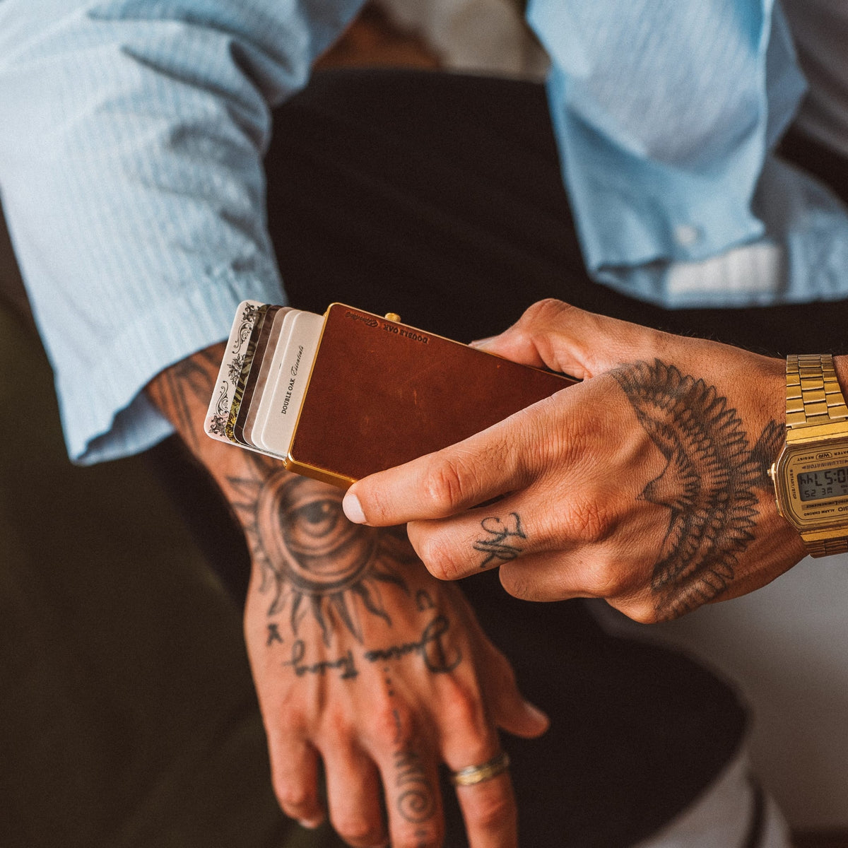 Brown leather Mod wallet with card stack, held by tattooed hand