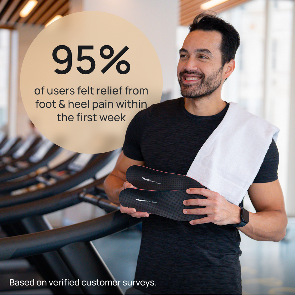Black orthotic insoles held in hand near exercise equipment