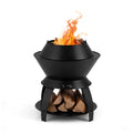 Black metal fire pit bowl with side stand supports and visible flame and logs