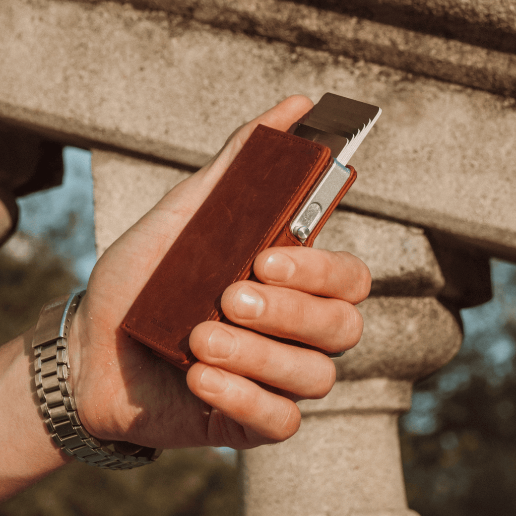 Brown leather bifold wallet with cards and metal clasp partially visible