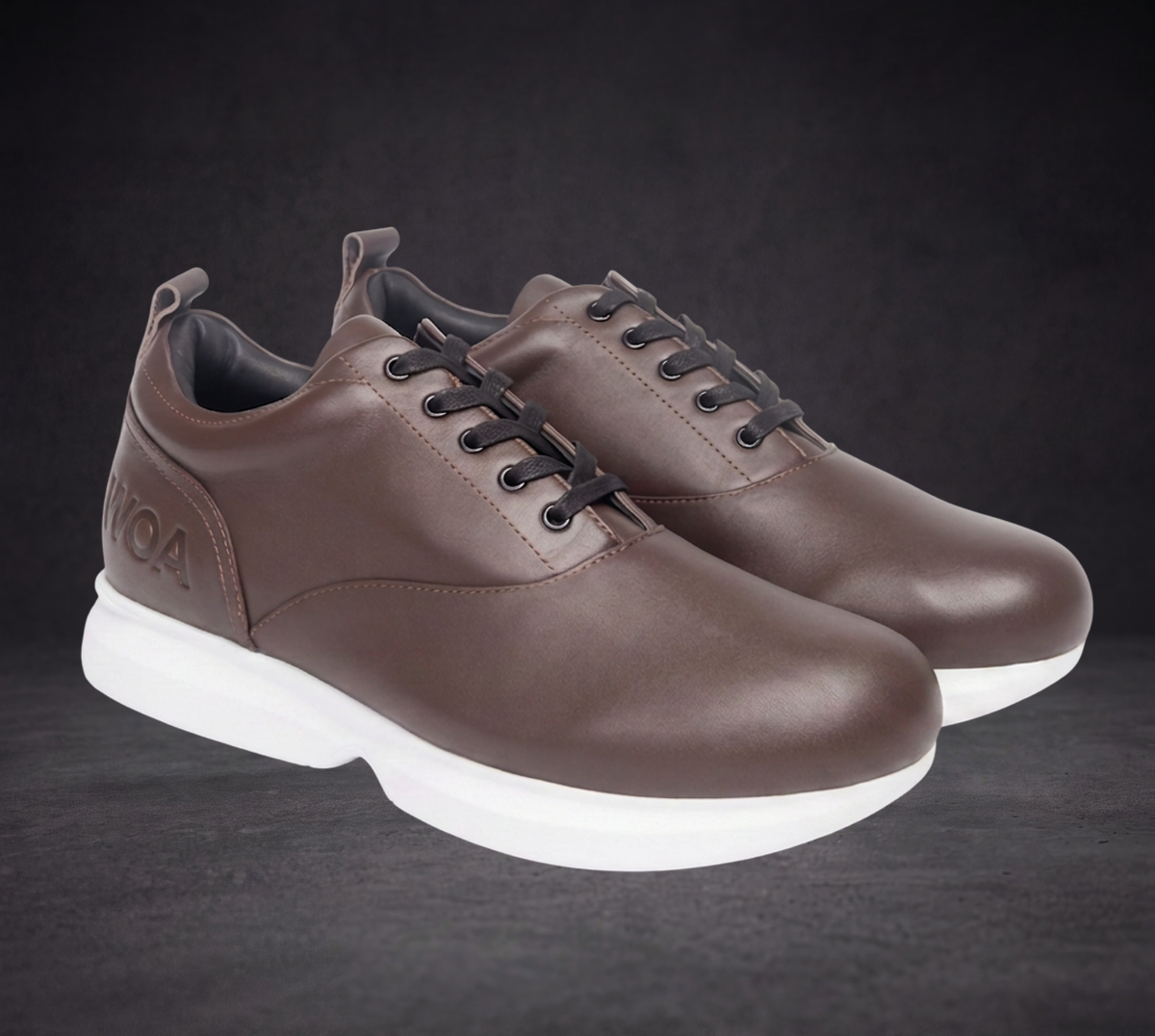 Pair of WOA brown low-top sneakers, lace-up with white soles, front three-quarter view