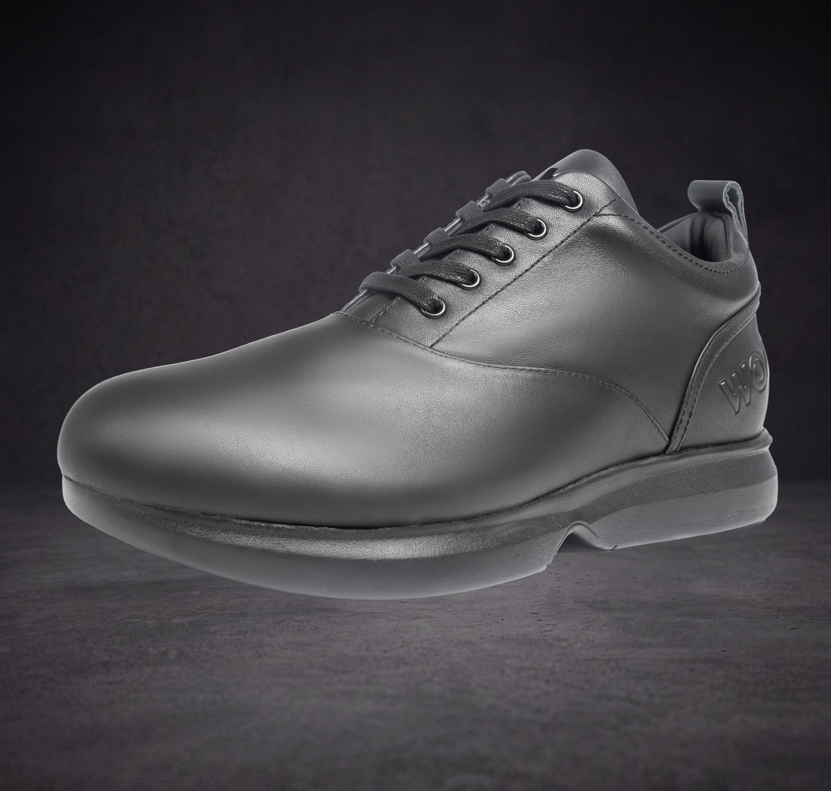 WOA low-top sneaker front view, dark leather upper with lace-up and side logo