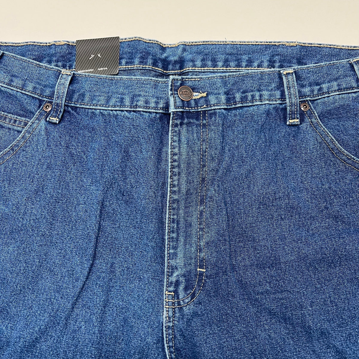 Relaxed carpenter jeans waistband with button fly, belt loops, and front patch pockets.