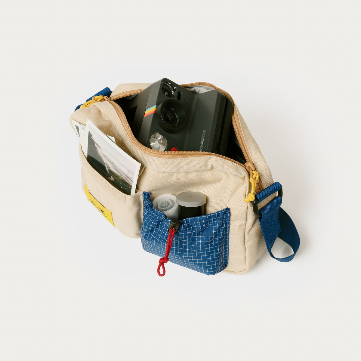 Cream shoulder bag with blue front pocket and organizer-style compartments