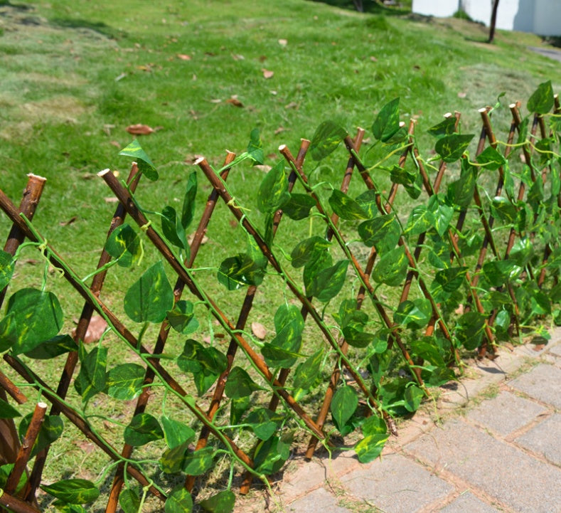 Expandable wooden plant trellis fence detail with brown stakes and green leaves