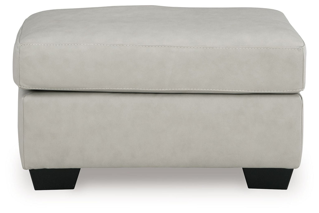Light gray upholstered ottoman with stitched cushion top and dark legs