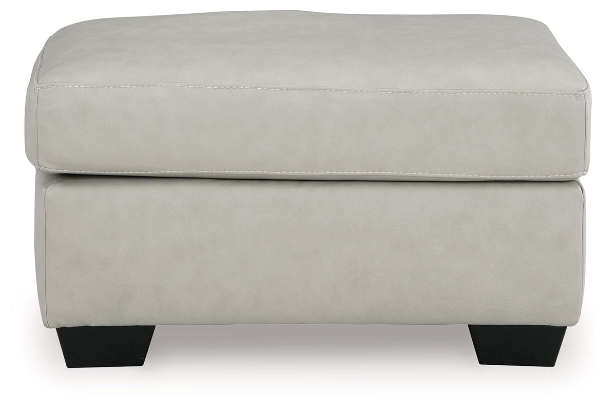 Light gray upholstered ottoman with stitched cushion top and dark legs