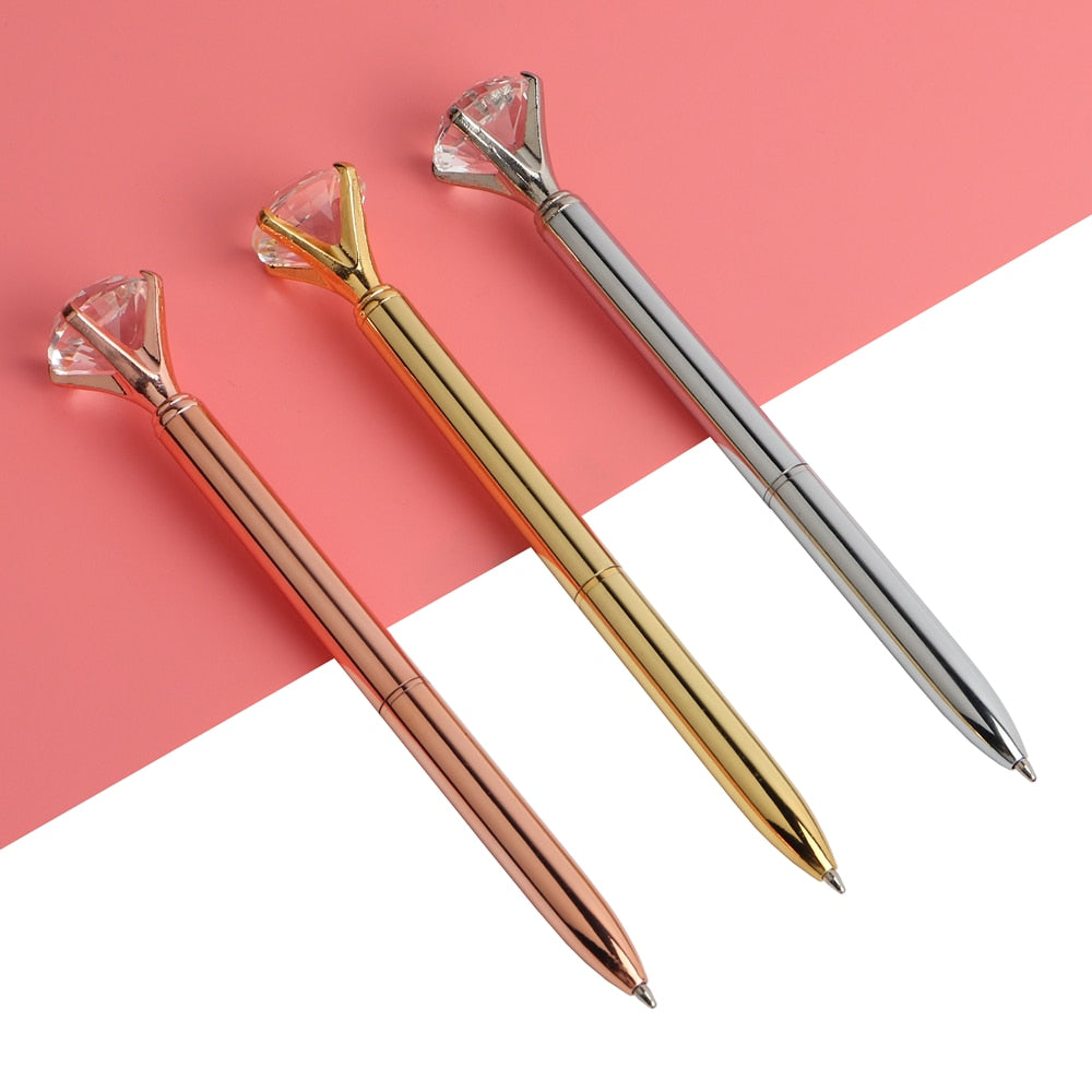 Gem-top metal ballpoint pens in rose gold, gold, and silver with faceted caps