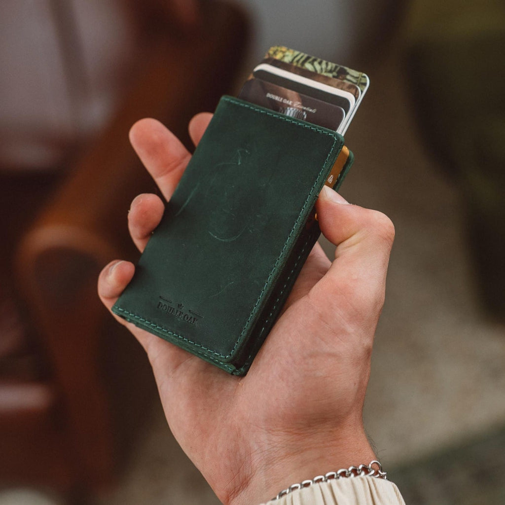 Bifold leather wallet in deep green with stitched seams and embossed logo