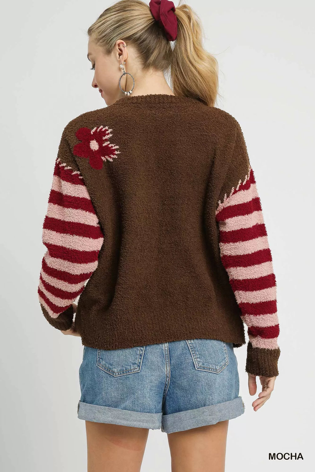 Mocha brown back view sweater with red striped sleeves and small flower graphic