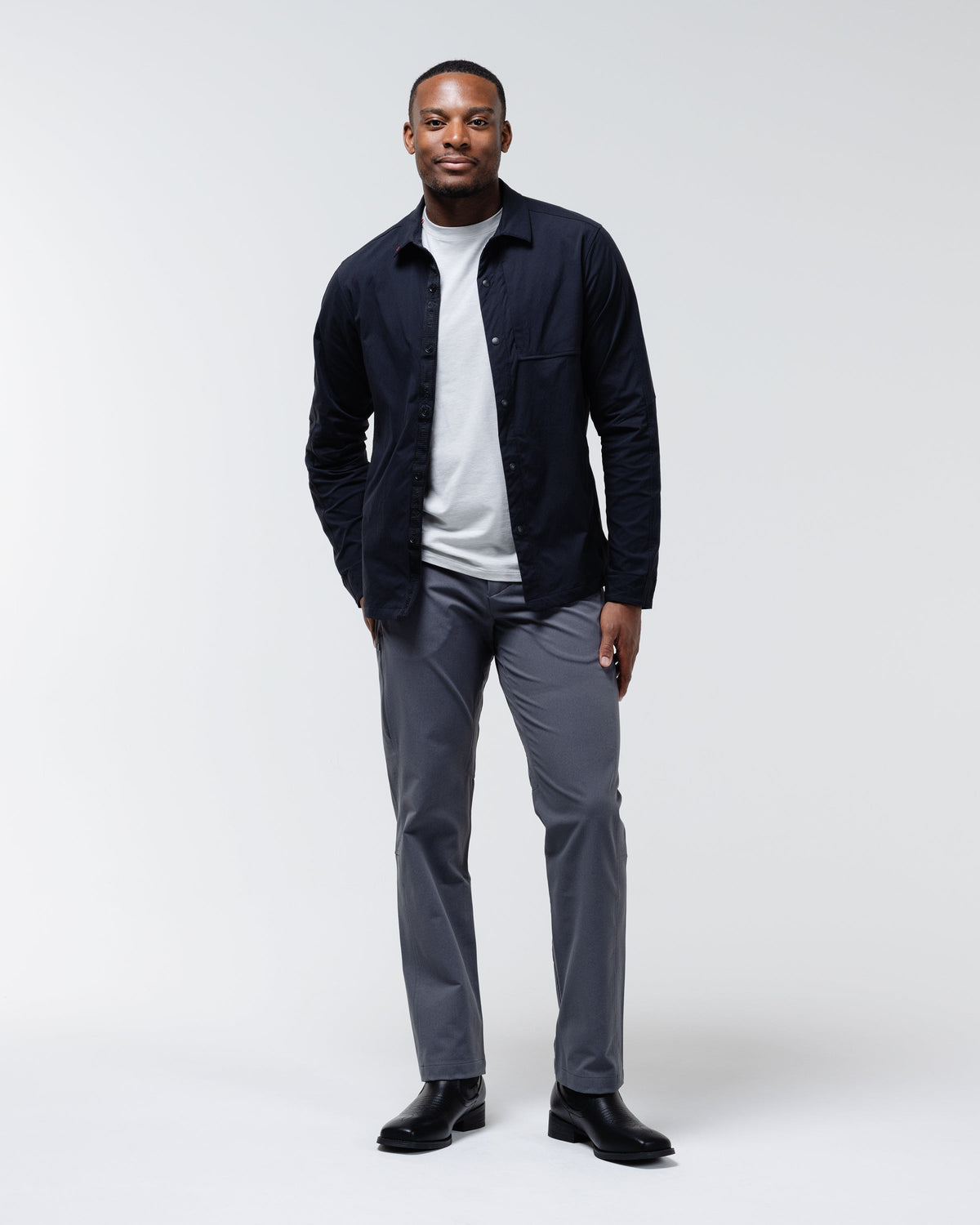 Charcoal chino pants styled with a dark jacket and straight-leg hem finish