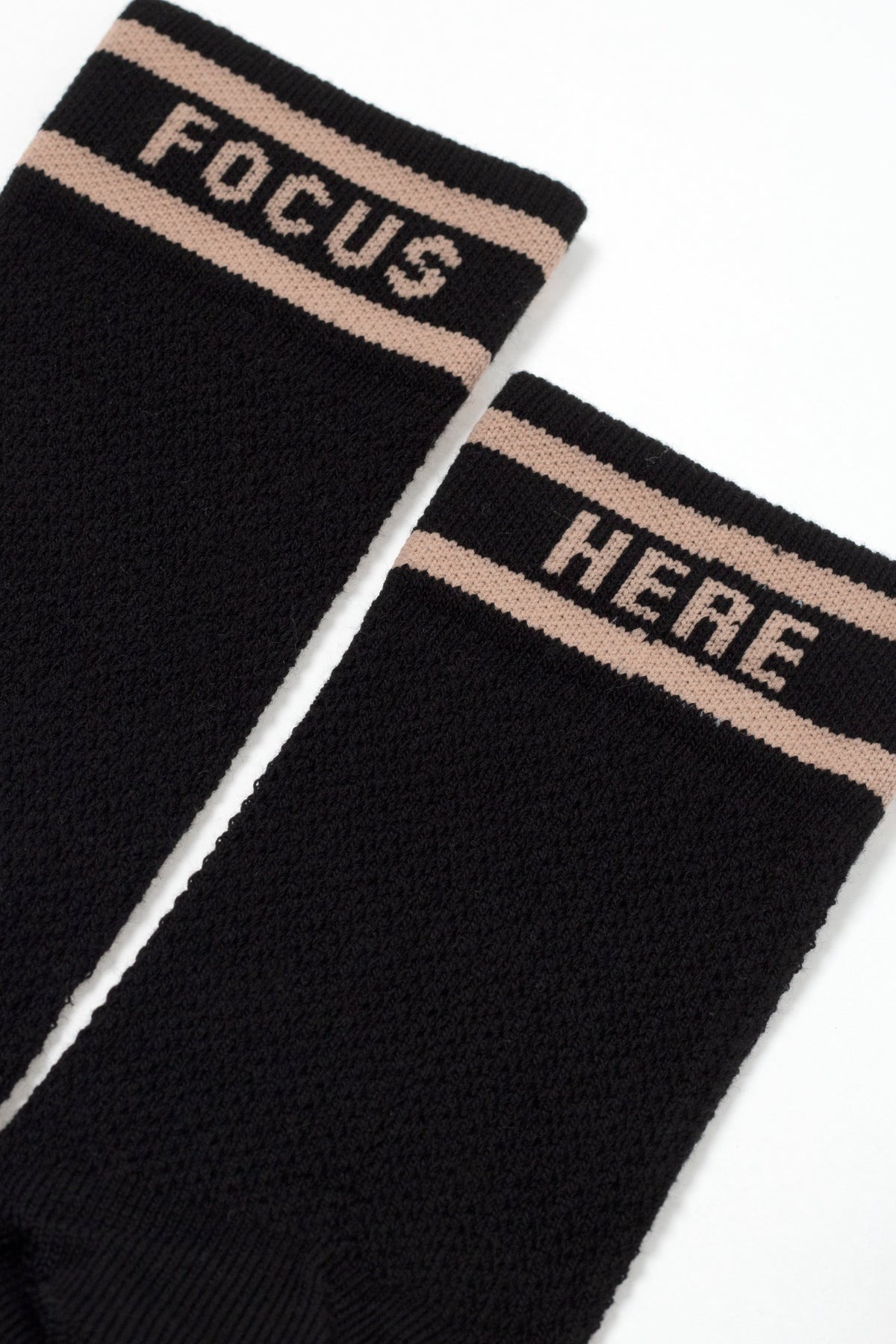 Black long cotton socks close-up, 'FOCUS' and 'HERE' text cuff bands