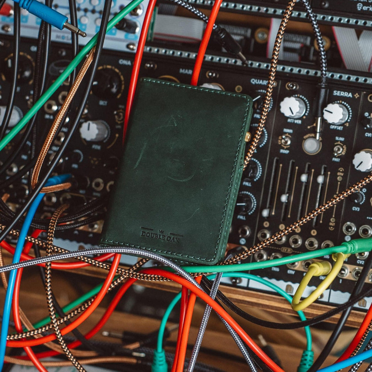 Deep green bifold wallet on a modular synthesizer panel