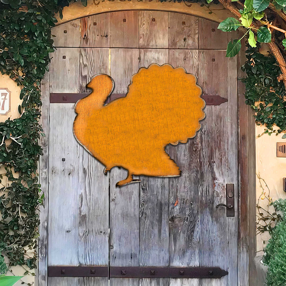 Orange wooden turkey door hanger mounted on a wooden door panel