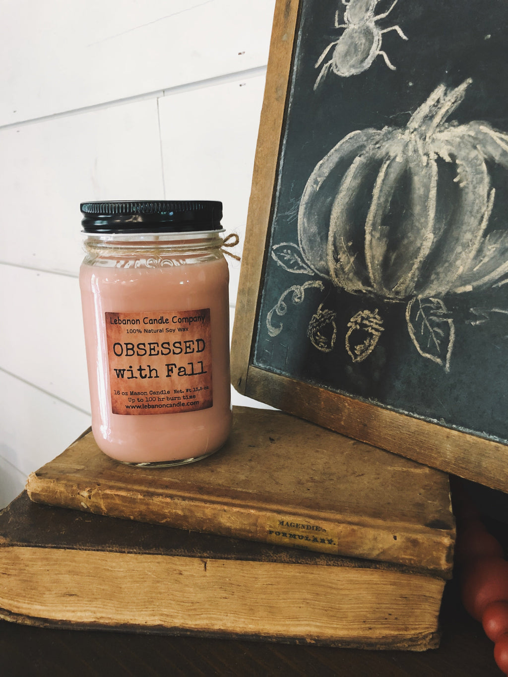 Pink jar candle with black lid, twine bow, and printed label front
