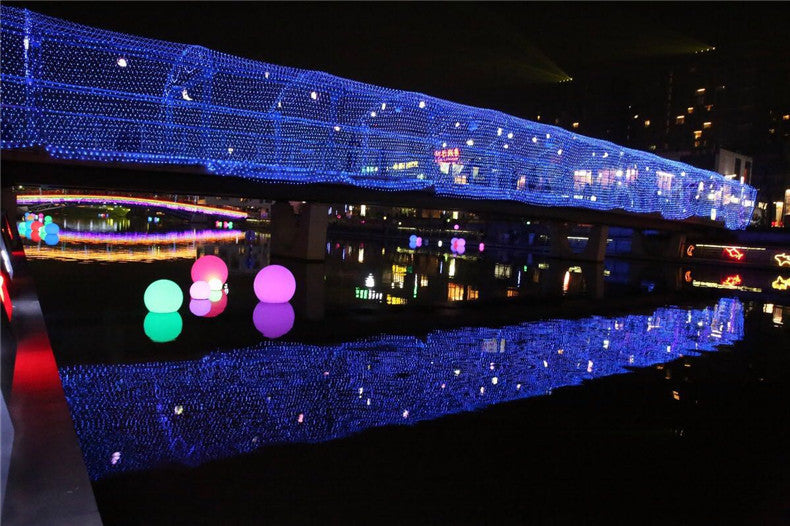 Blue LED fishnet string lights with colorful spherical accent lights along a structure