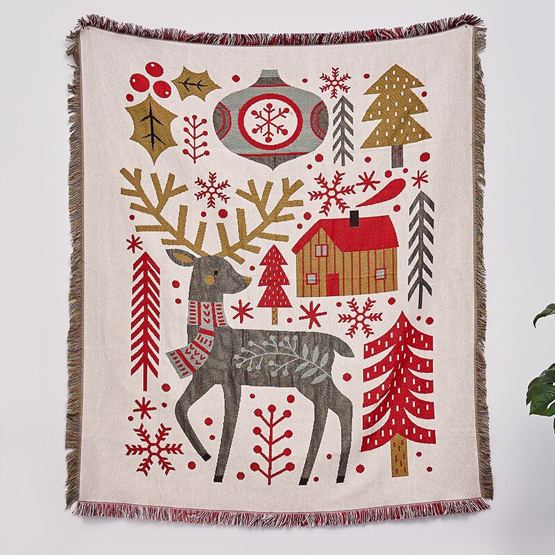 Beige towel blanket with winter village and deer, red-and-green holiday prints, fringed