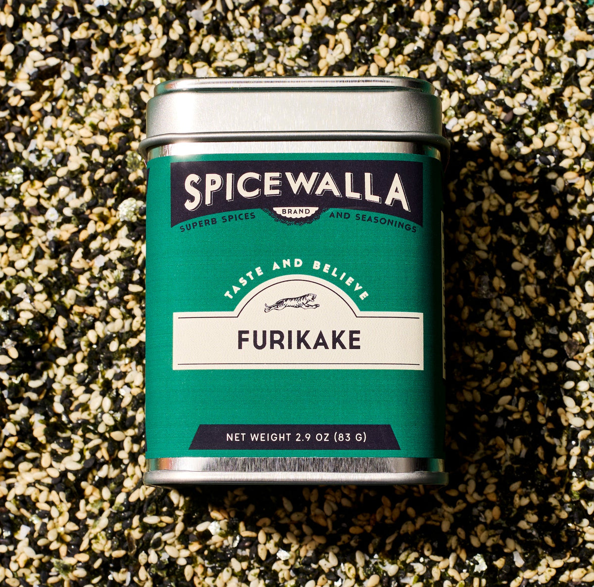 Close-up Furikake seasoning tin on sesame spice seed bed