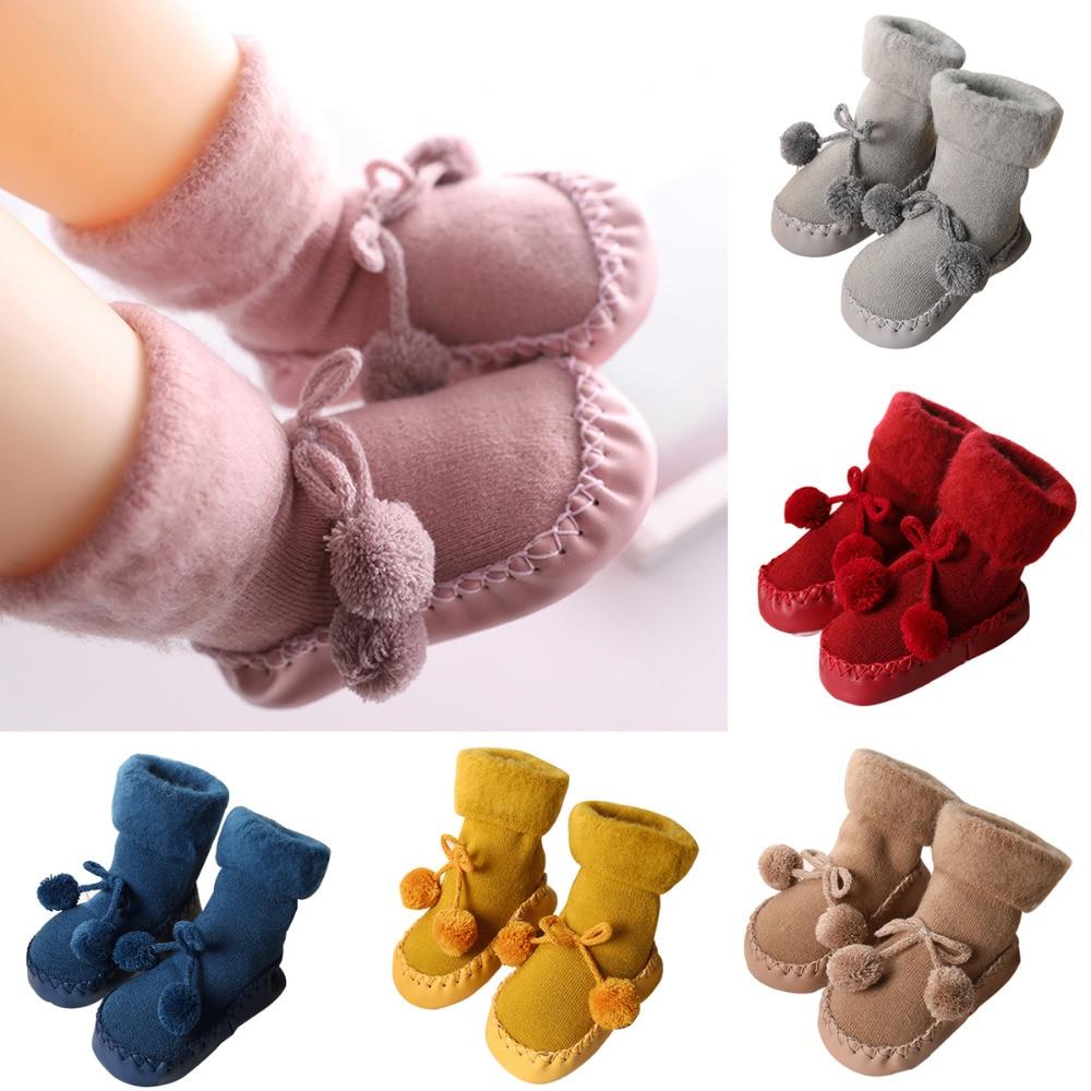 Pair of baby socks in pink with pom-pom bows and looped cuffs