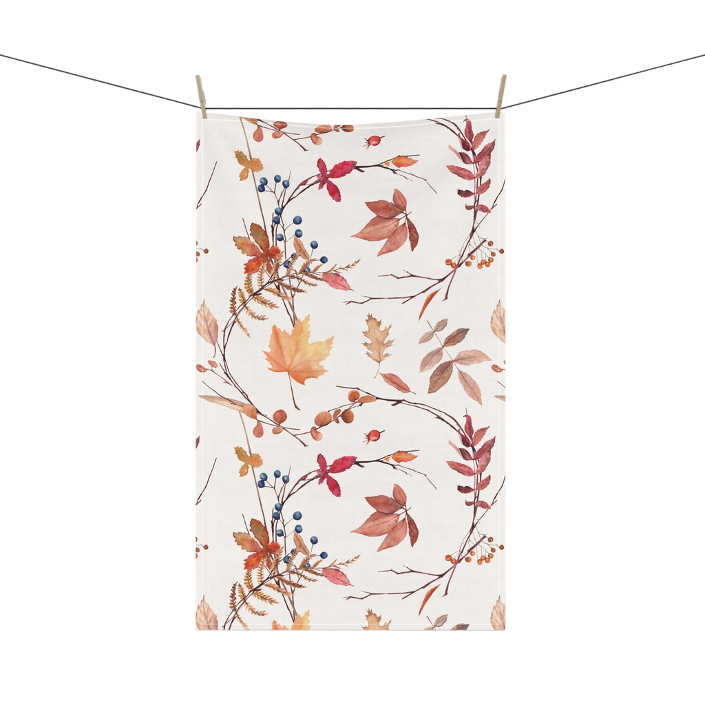 Hanging fall foliage tea towel with leaf and berry pattern and clothespin