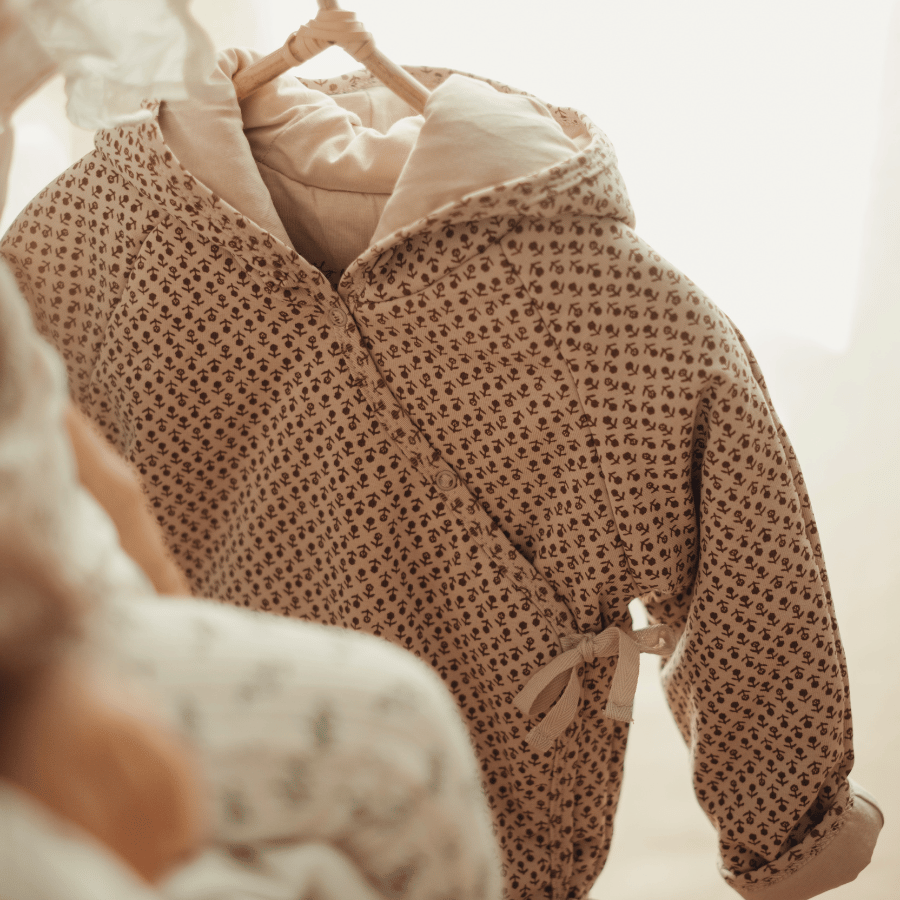 Hooded baby jacket in allover print with front placket and drawstring waist