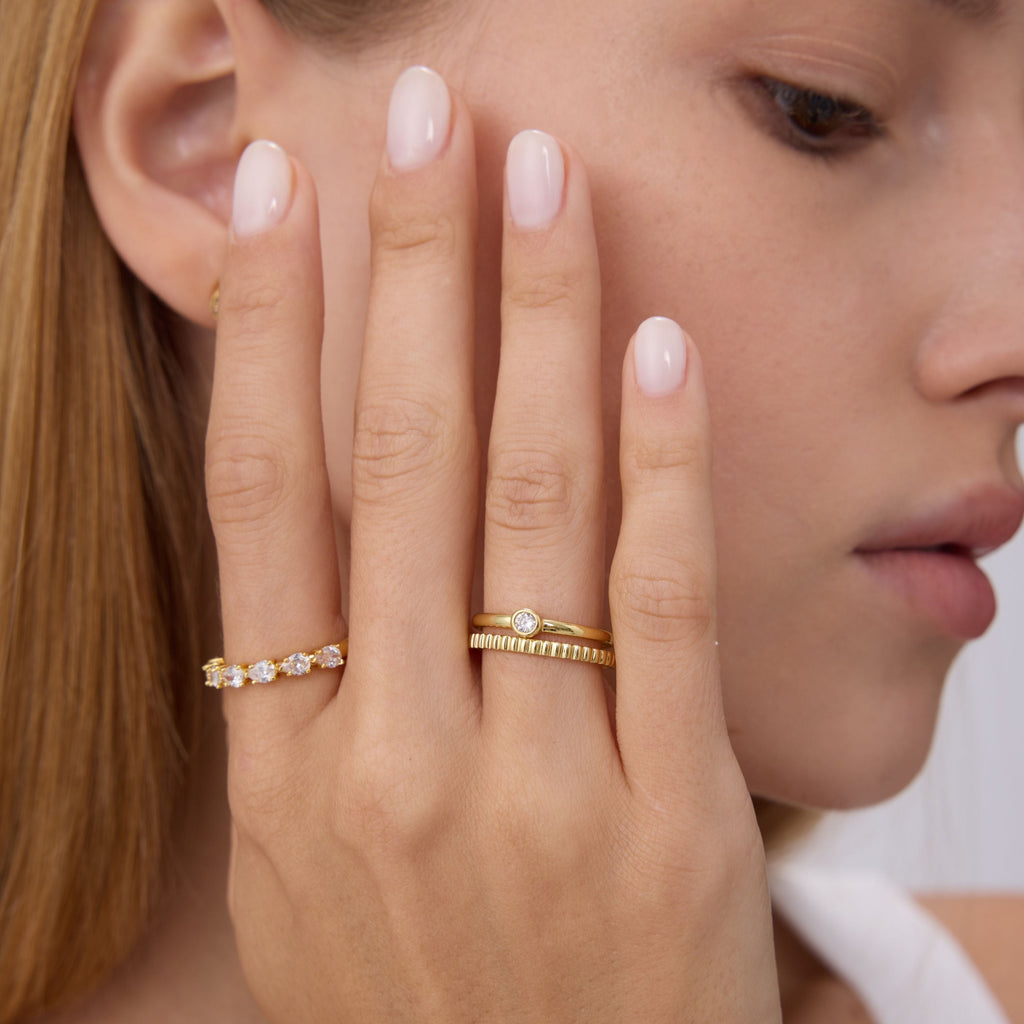 Gold bezel stone ring with round center stone, slim band