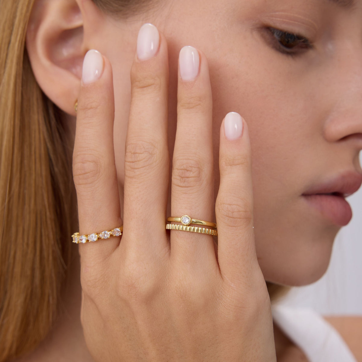 Gold bezel stone ring with round center stone, slim band