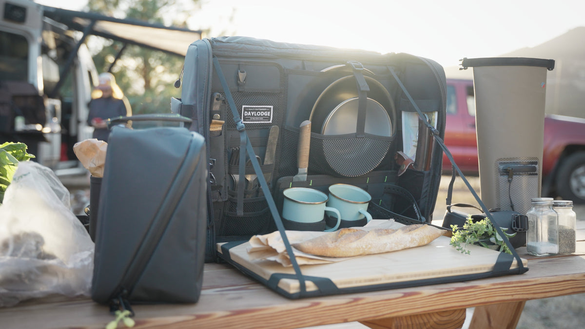 Blue-gray mobile camp kitchen table bag with bamboo cutting board and cookware storage