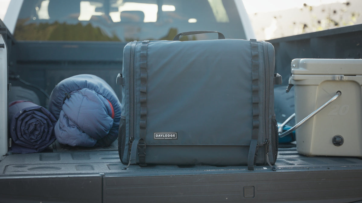 Blue mobile camp kitchen bag stored in a truck bed with side dividers