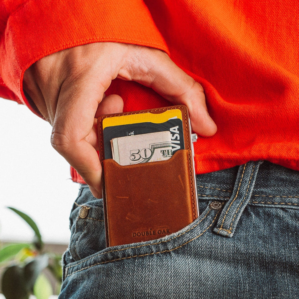 Brown leather mod wallet tucked near jeans pocket, card visible through window