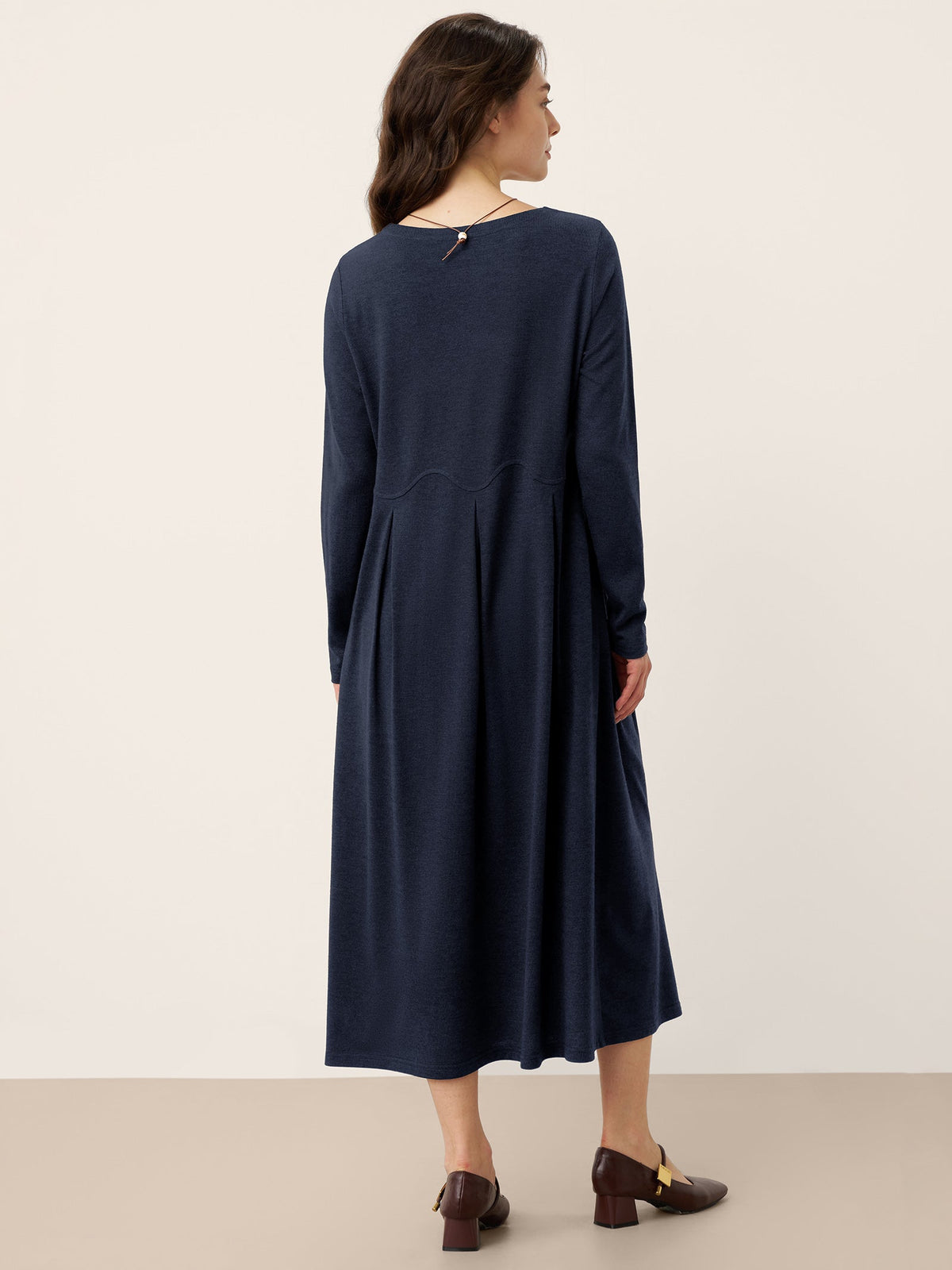 CALISTA navy wool midi dress, back view, arc panel pleats and long sleeves