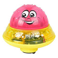 Pink and yellow smiling UFO water sprinkler toy with clear dome and base