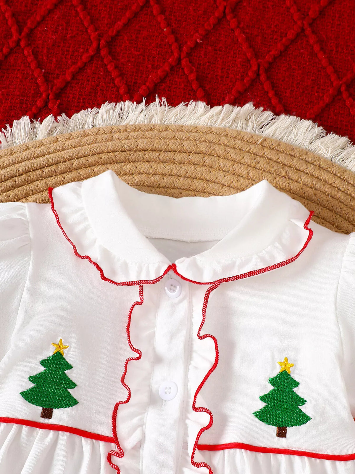 White dress bodice with red scalloped trim and embroidered tree and star accents
