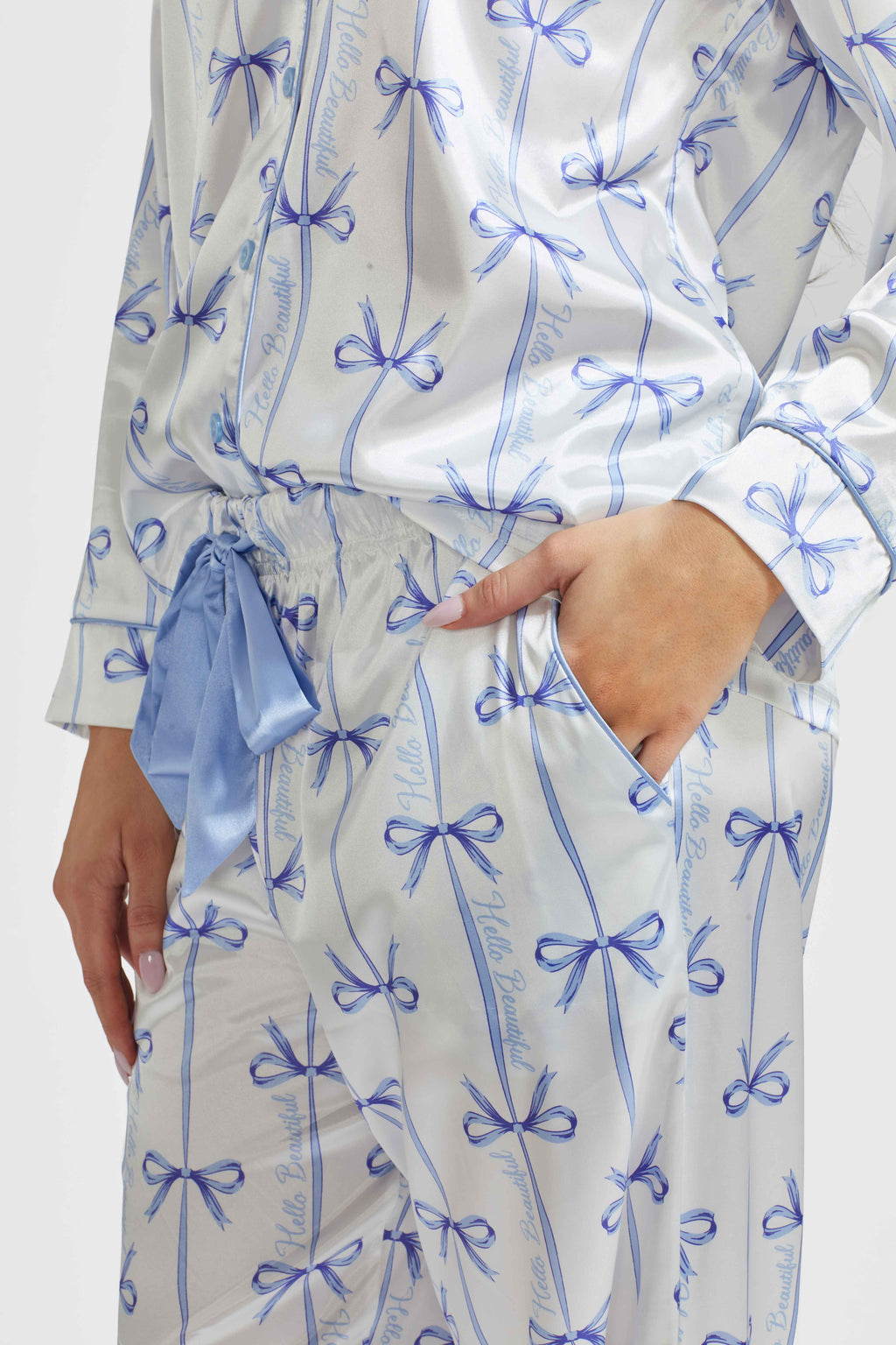 Light blue satin pajama top and pants close-up with bow print and ruched waist